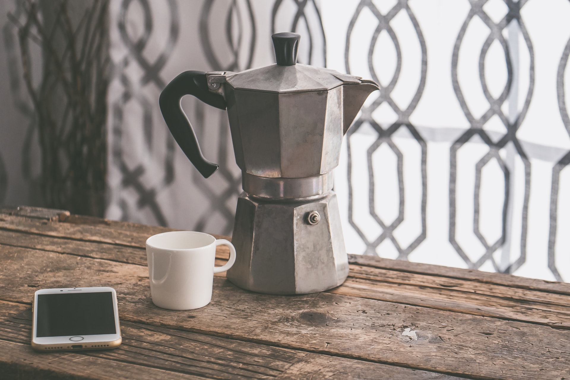 A drip coffee maker and a cup of brewed coffee.