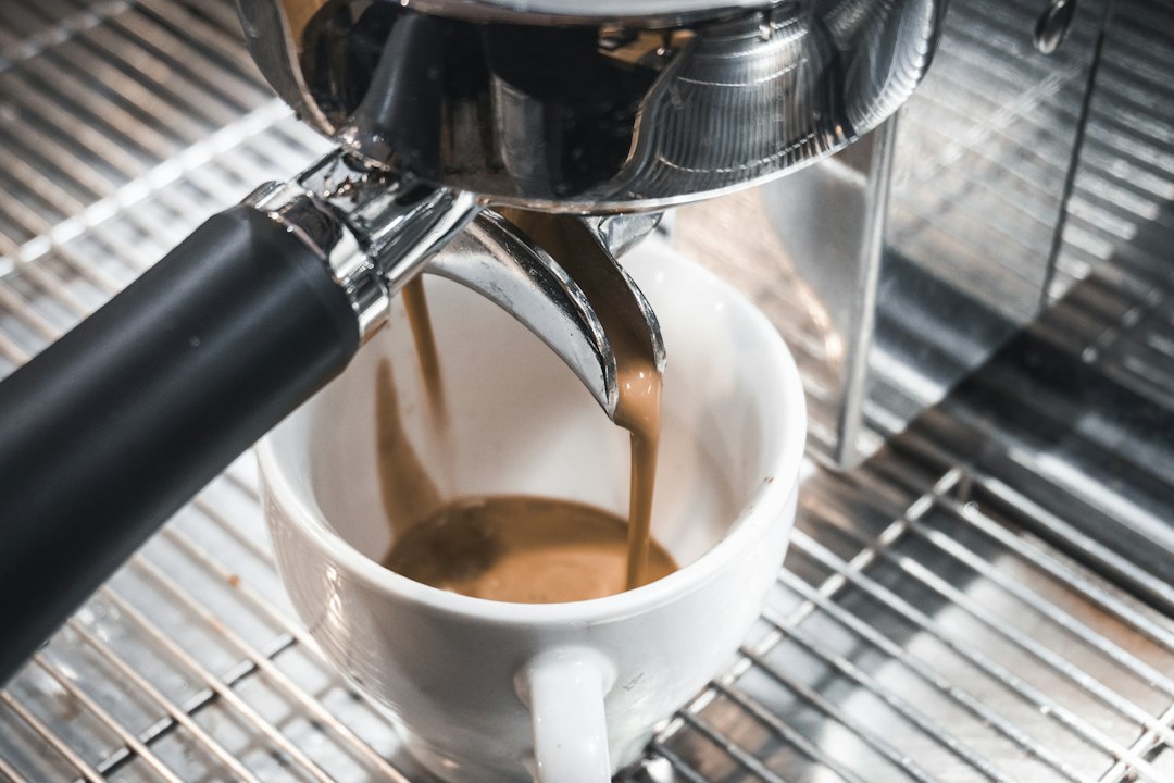 Black coffee machine brewing illustrating Fellow Ode vs Baratza Encore.