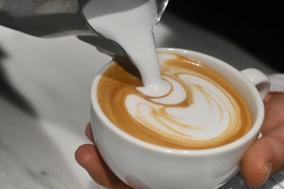 Coffee with milk in a glass cup illustrating Nespresso vs Keurig pod systems.