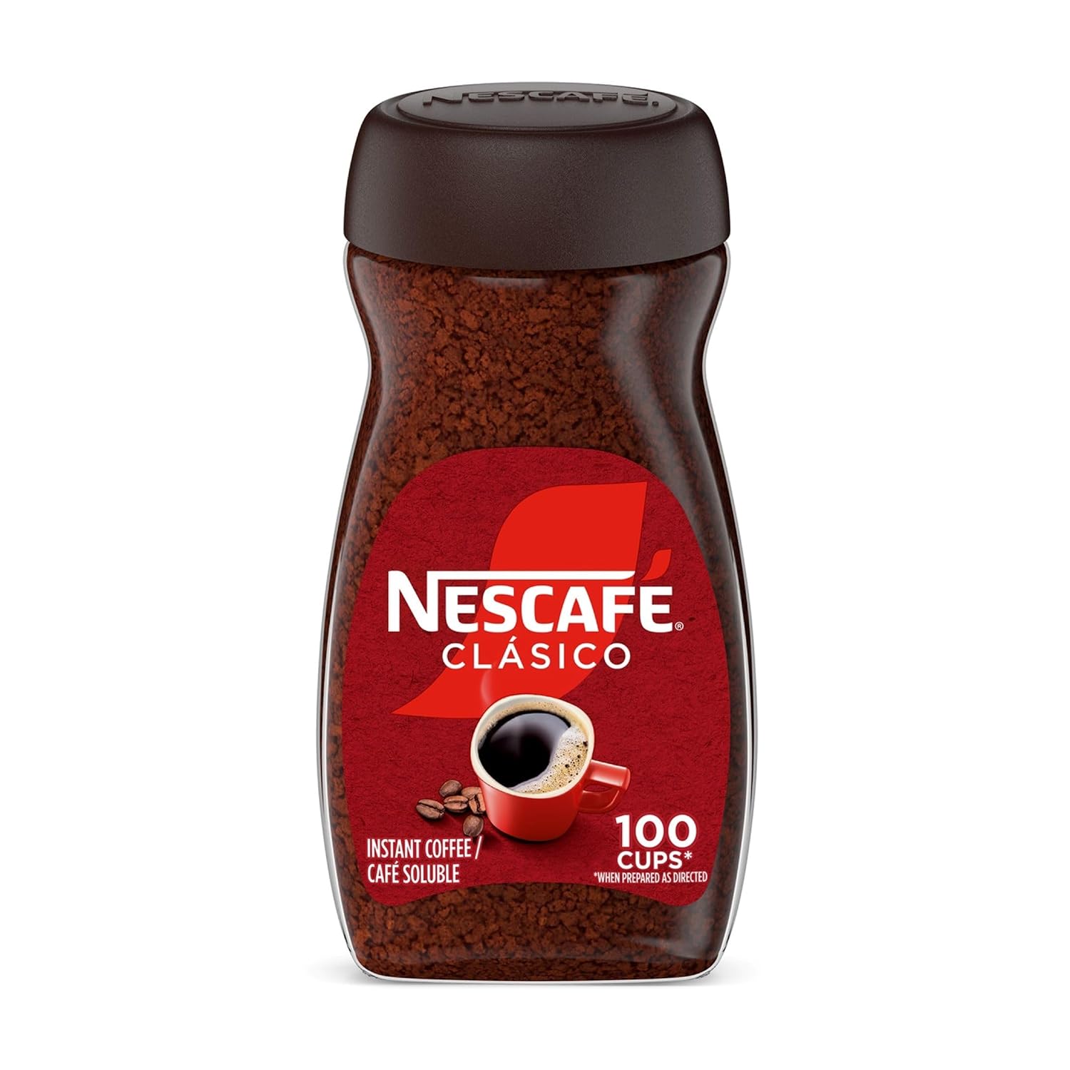 A glass of iced milk topped with fluffy whipped dalgona coffee beside a bowl of whipped coffee, a whisk, and instant coffee granules on a white counter.